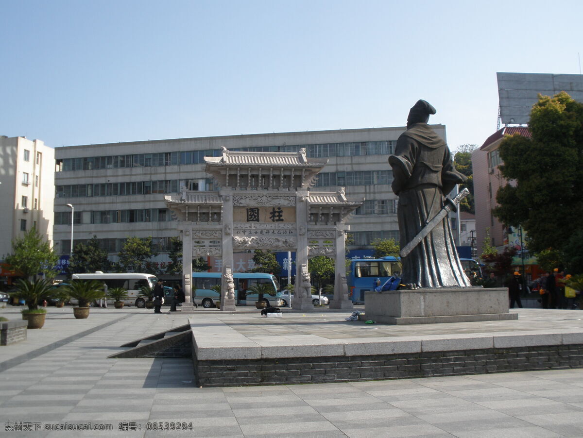 王阳明 雕像 牌坊 反面 余姚 北边 铜质 全身 往南是牌坊 上 两个 大字 柱国 再 南边 排 盆栽 铁树 远处是马路 旅游车 房屋 蓝天 王阳明故居 国内旅游 旅游摄影